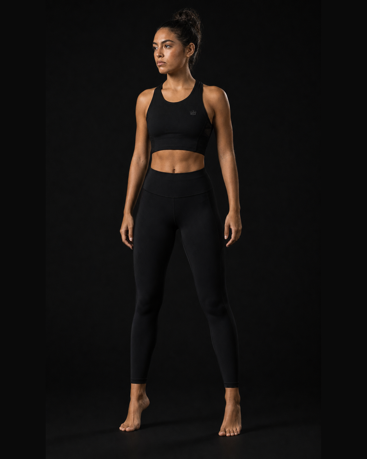 Model wearing Originals CA cropped black performance tank with crown, studio portrait