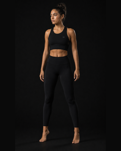 Model wearing Originals CA cropped black performance tank with crown, studio portrait