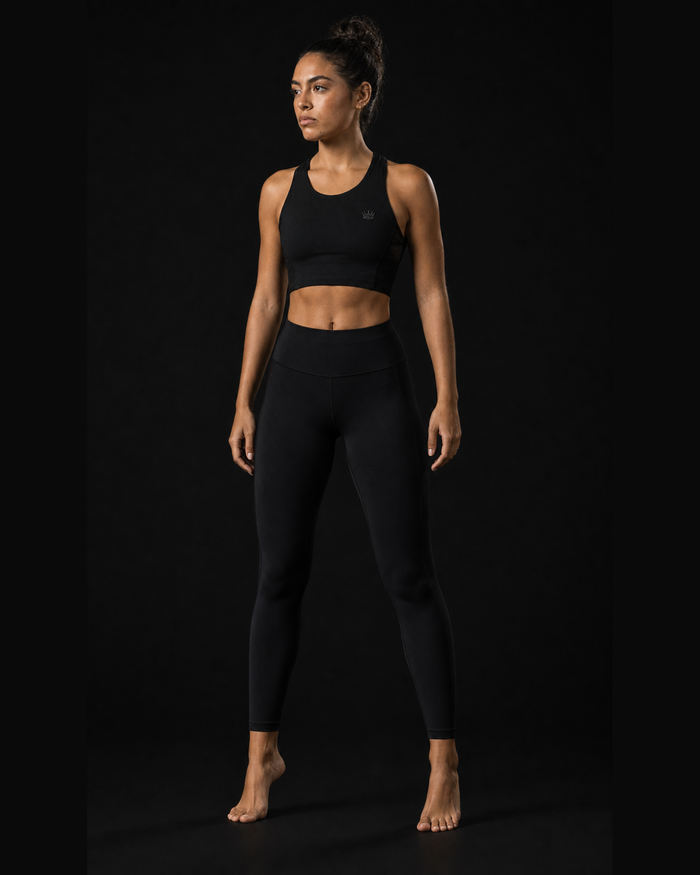 Model wearing Originals CA cropped black performance tank with crown, studio portrait