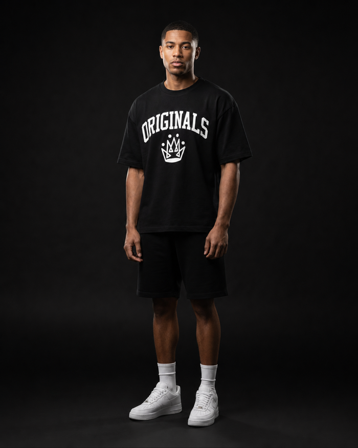 Model wearing Originals CA heavyweight black tee with crown emblem, studio portrait