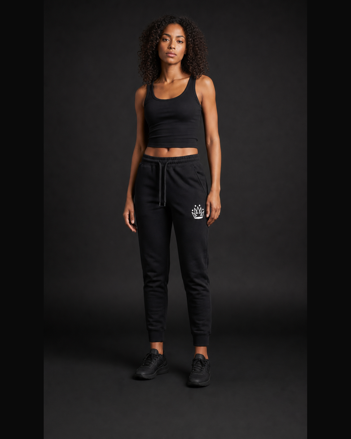 Model wearing Originals CA black jogger with crown, studio portrait
