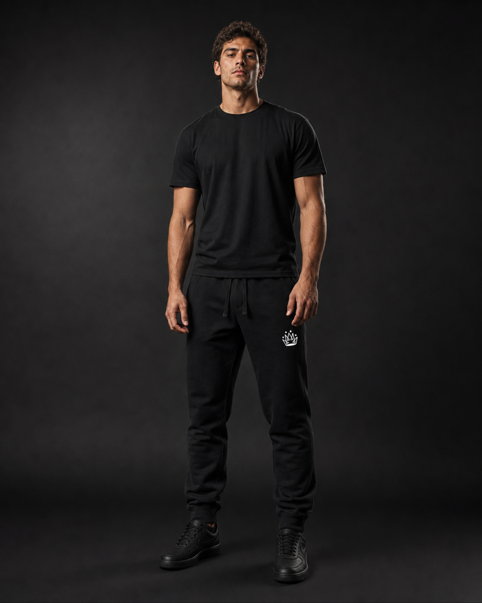 Model wearing Originals CA black sweatpants with crown embroidery, studio portrait