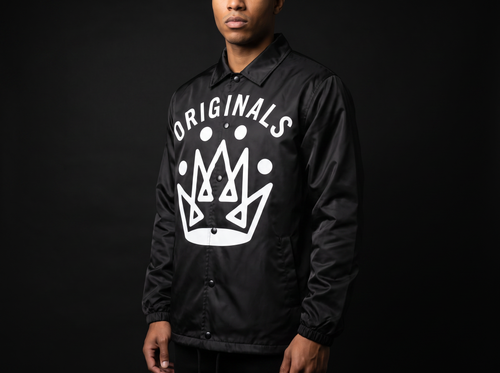 Model wearing Originals matte-black coaches jacket with white ORIGINALS crown across chest