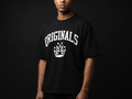 Model wearing Originals matte-black heavyweight tee with large white ORIGINALS crown across chest