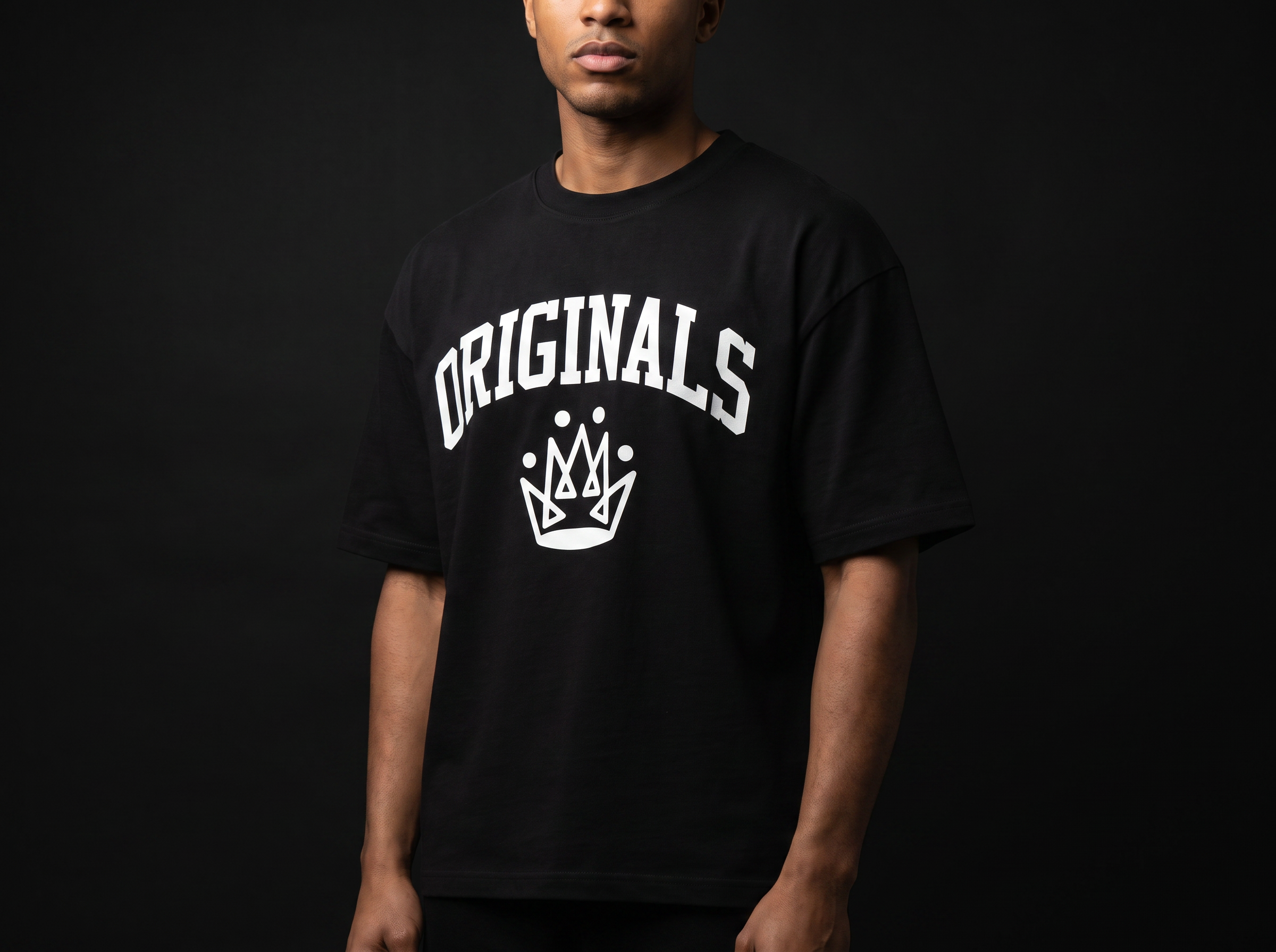 Model wearing Originals matte-black heavyweight tee with large white ORIGINALS crown across chest