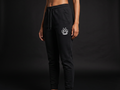 Model wearing Originals matte-black tapered jogger with small white crown at hip