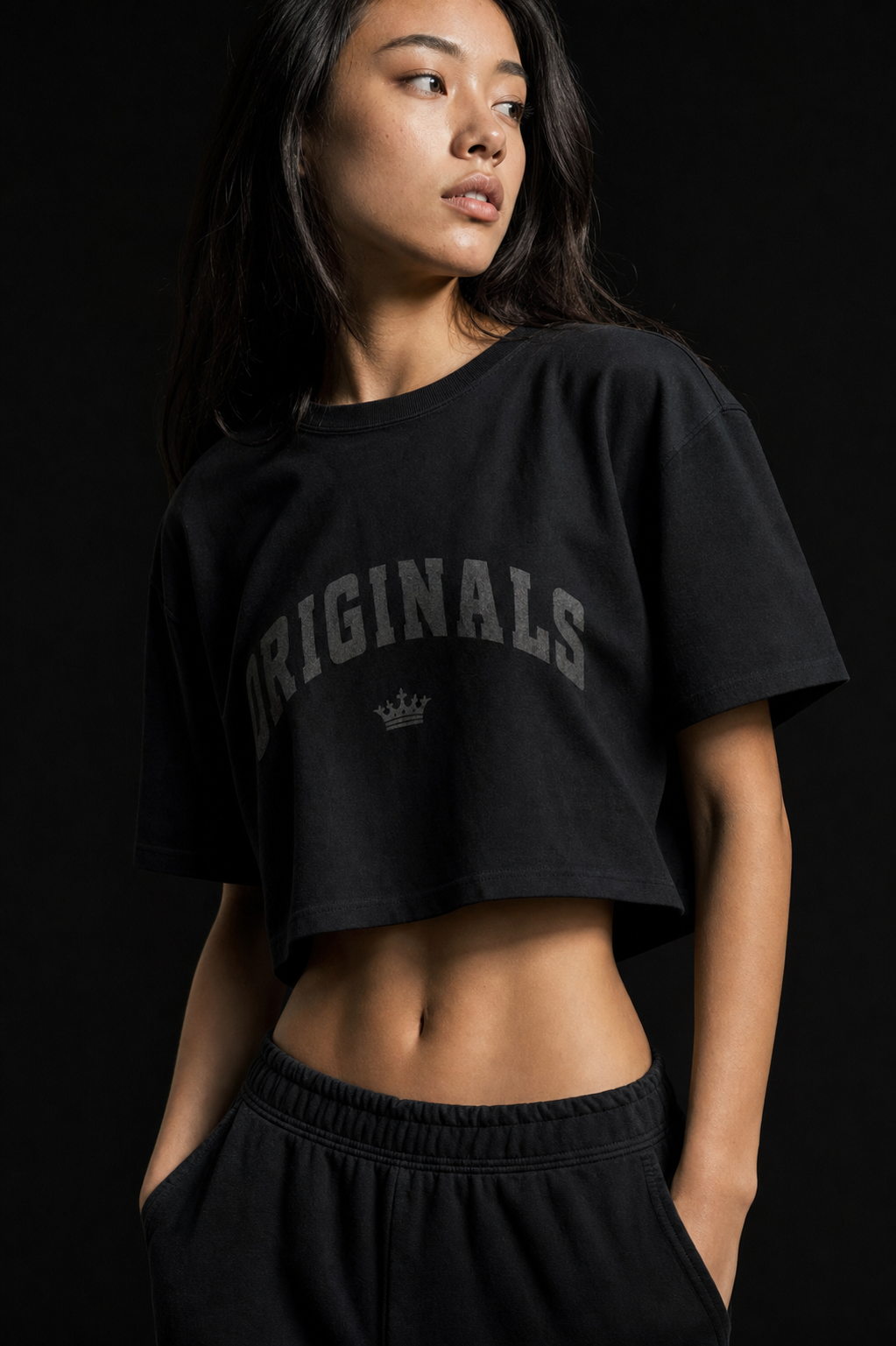 Model wearing Originals cropped black tee with arched wordmark and crown