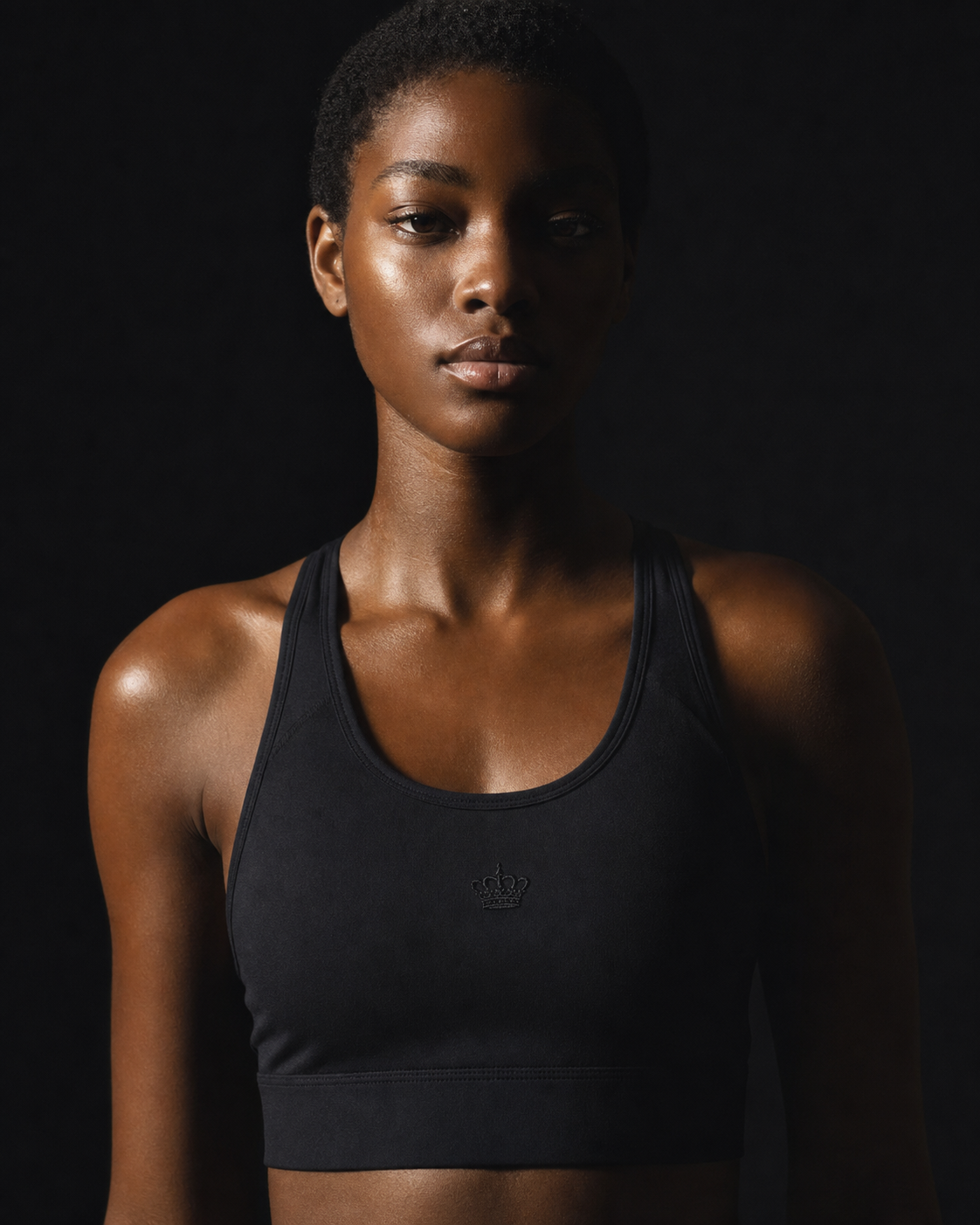 Model wearing Originals black performance sports bra with crown emblem